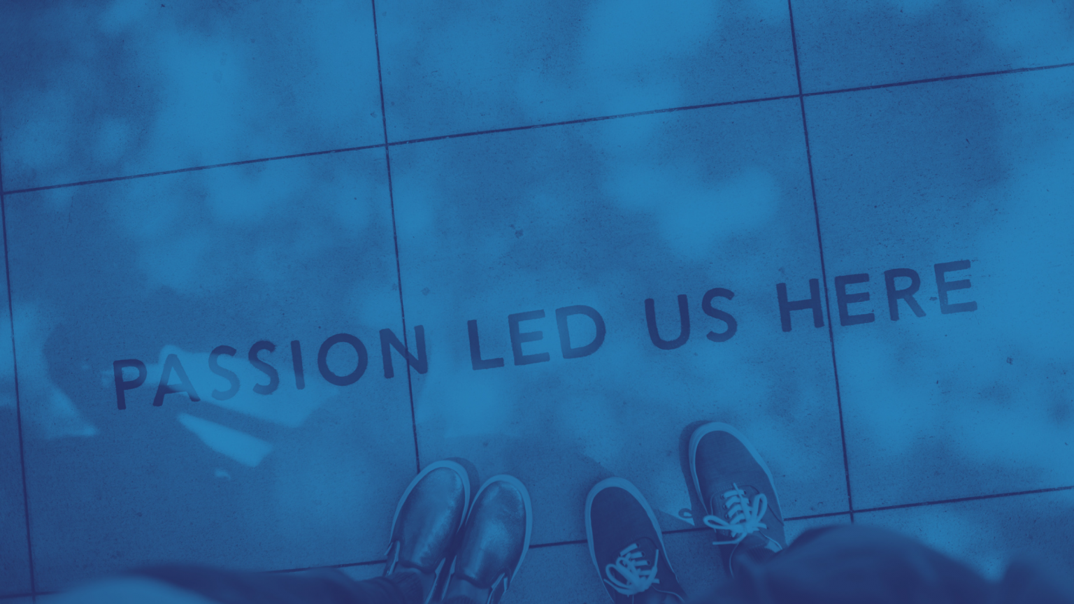 Our Story - looking down to two sets of sneakers on pavement that reads, "Passion Led Us Here"